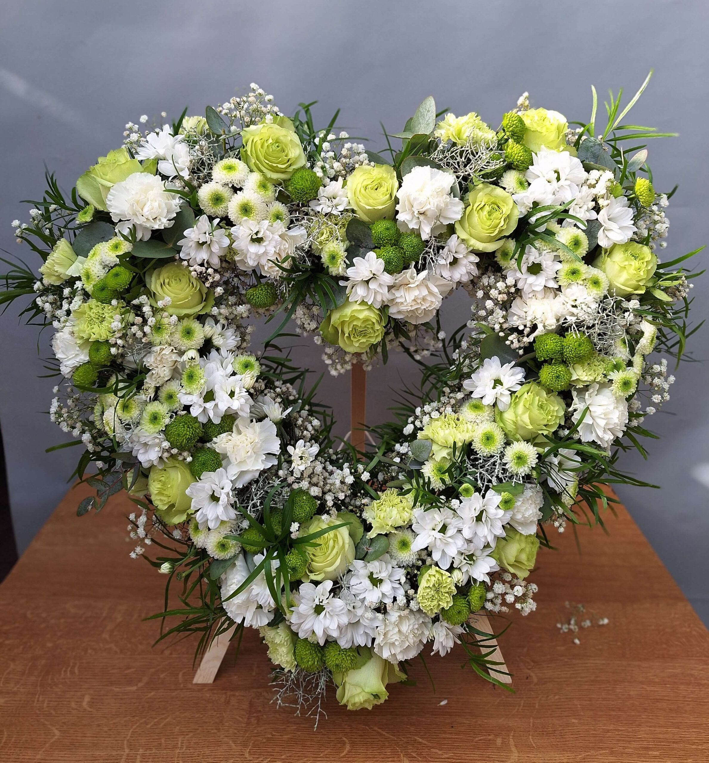 Wieniec pogrzebowy w kształcie serca z białych i zielonych kwiatów – elegancka kompozycja od kwiaciarni w Suszcu