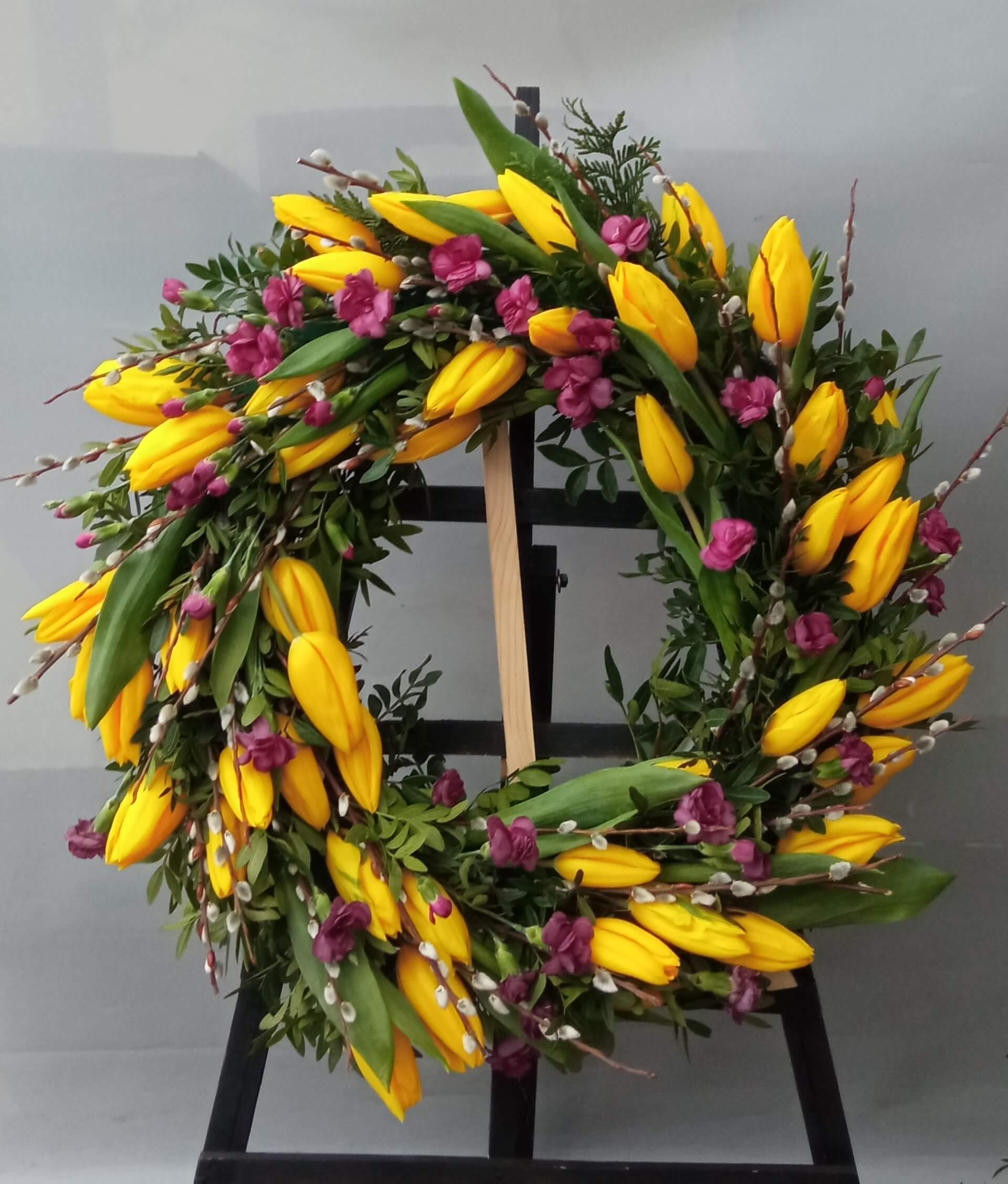 wieniec pogrzebowy z żółtych tulipanów i fioletowych kwiatów
